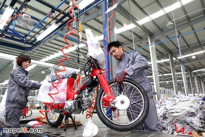 重慶安第斯摩托車技術(shù)工人在自動(dòng)成車流水生產(chǎn)線組裝摩托車
